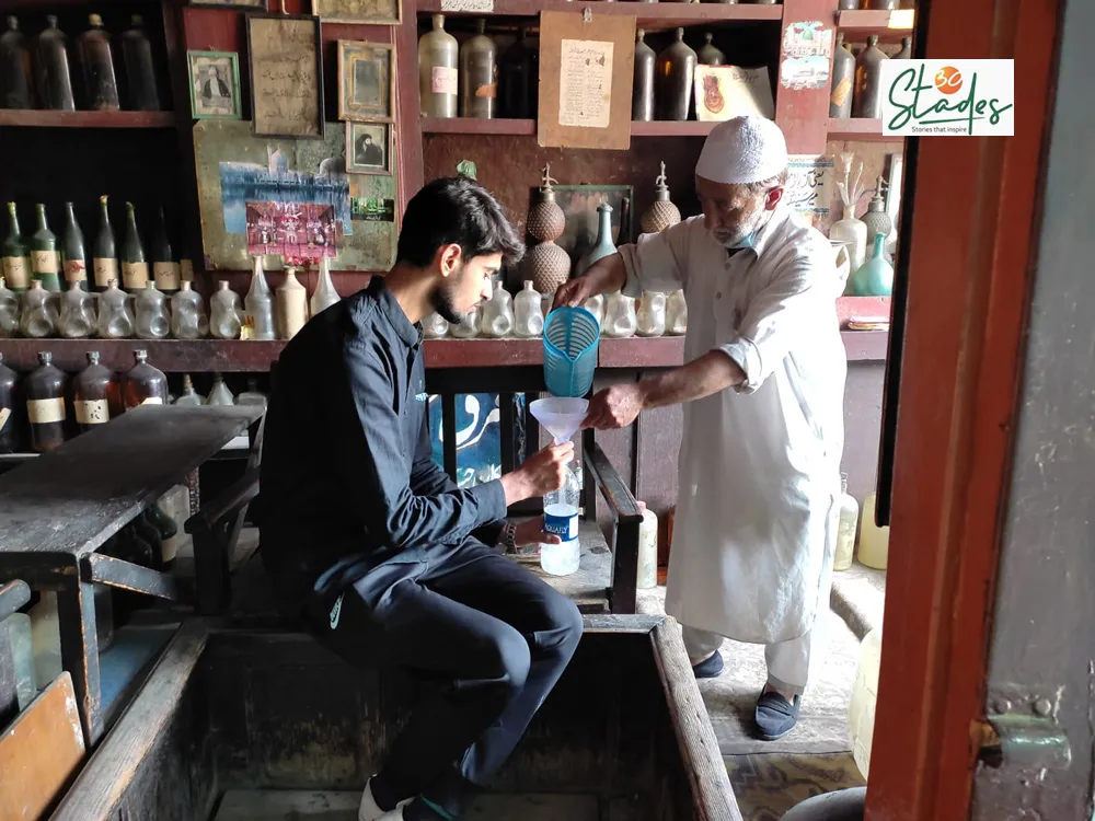 Abdul Aziz Kozgar pouring rosewater in a bottle. Pic: Parsa Mahjoob/Srinagar 30 stades