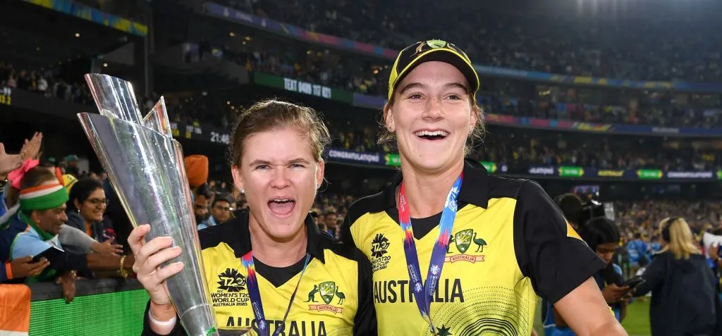 Jess Jonassen (L) and Annabel Sutherland (R) pose with the T20 World Cup trophy. © Getty Images