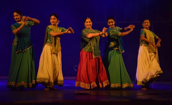 Uma Dogra with her students on stage. 