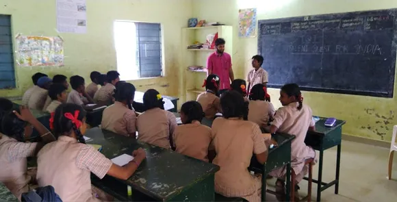 TQI volunteer with students at a government school. Pic: Facebook/@TqiTrust