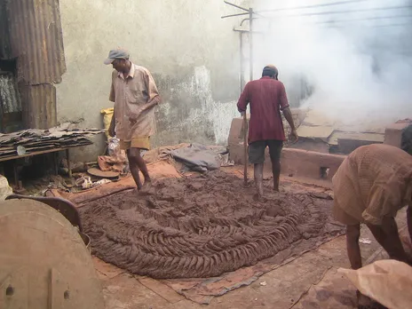 The clay is kneaded with feet to achieve a smooth consistency.