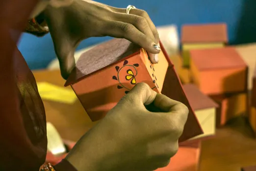 An artisan decorating a box with discarded flower petals. Pic: Gulmeher 30stades