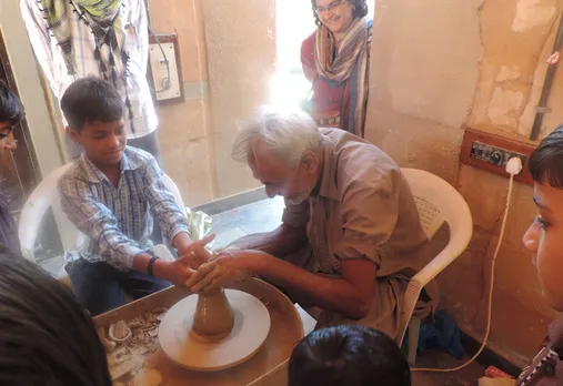Ismailbhai teaching students on the Khavda pottery wheel of kutch. Pic: Khamir 30 stades
