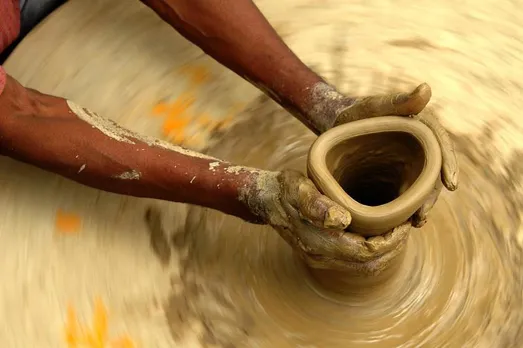 Expert hands give shape to diyas.  