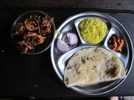 Maharashtra Cuisine Zunkha Bhakri Pithla 30stades Zunkha, bhakri with pithla (made from besan) served with achar and onion.