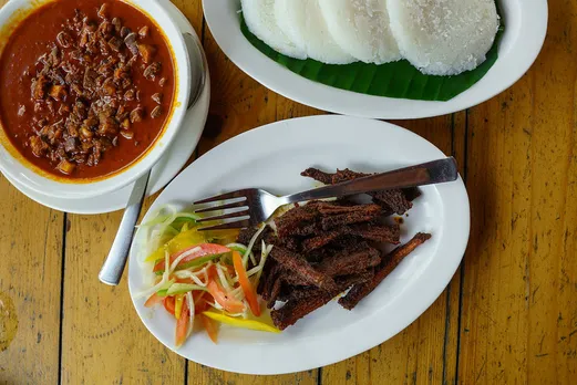 Sorpotel (a pork gravy prepared two-three days ahead of Christmas) with sannas (steamed rice cake). Also fried bombil fish here. Pic: Flickr