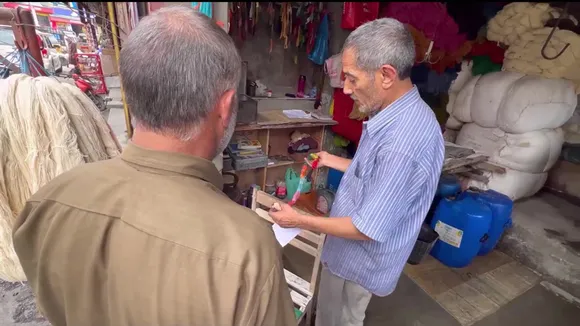 Bashir receiving an order from a customer. The details of colour shades have been written on a paper. Pic: Wasim Nabi 30stades