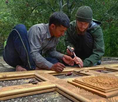 A craftsman sharing his wood carving knowledge with a guest at the campus. Pic: NORTH kath kuni 