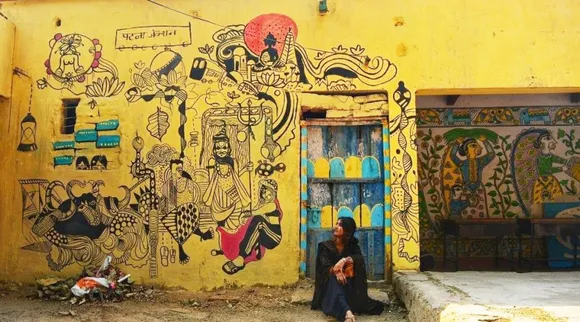 Ankita Raj sits with her wall art at Patna Junction; on right is Madhubani art form. Pic: La Pintura 30 stades