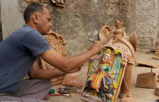 An artisan painting a Molela art piece - a tribal deity. Pic: Flickr 30 stades